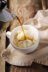 Coffee being poured from a moka pot into a cup of vanilla ice cream, creating an affogato